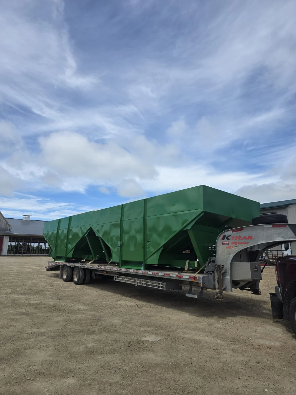 Large green finished hoppers loaded on a trailer