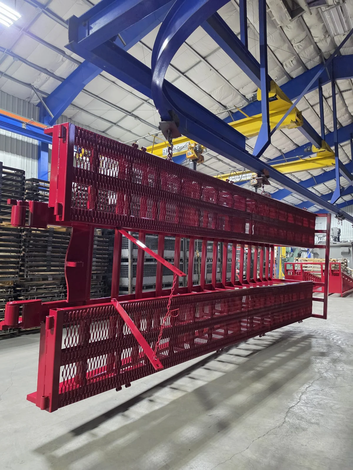 Red coated industrial racks suspended inside the facility